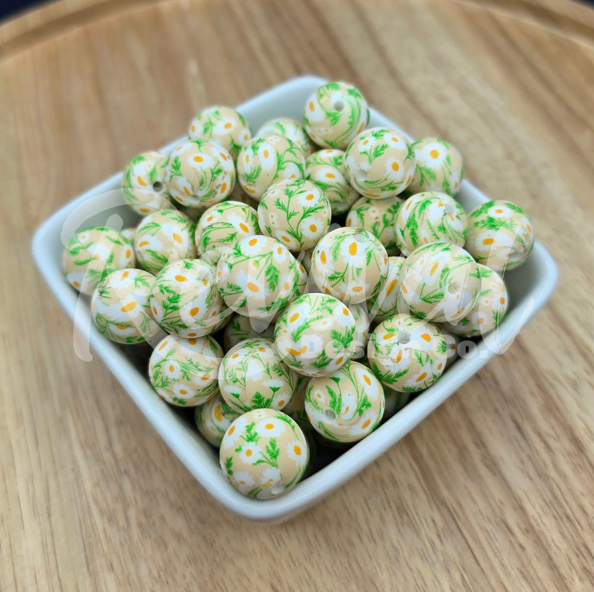 White container filled with green and white floral spherical beads on a wooden surface with a dark background