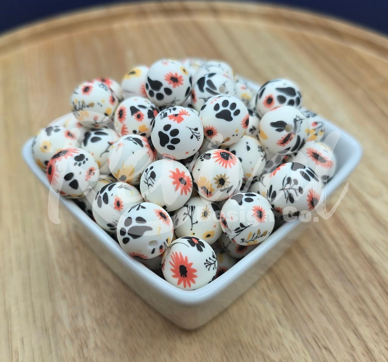White container filled with small decorative beads on a wooden surface with a dark blue background