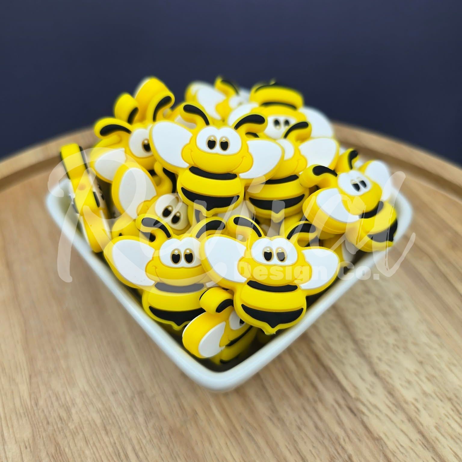 Bee-shaped beads on a white plate with a dark background