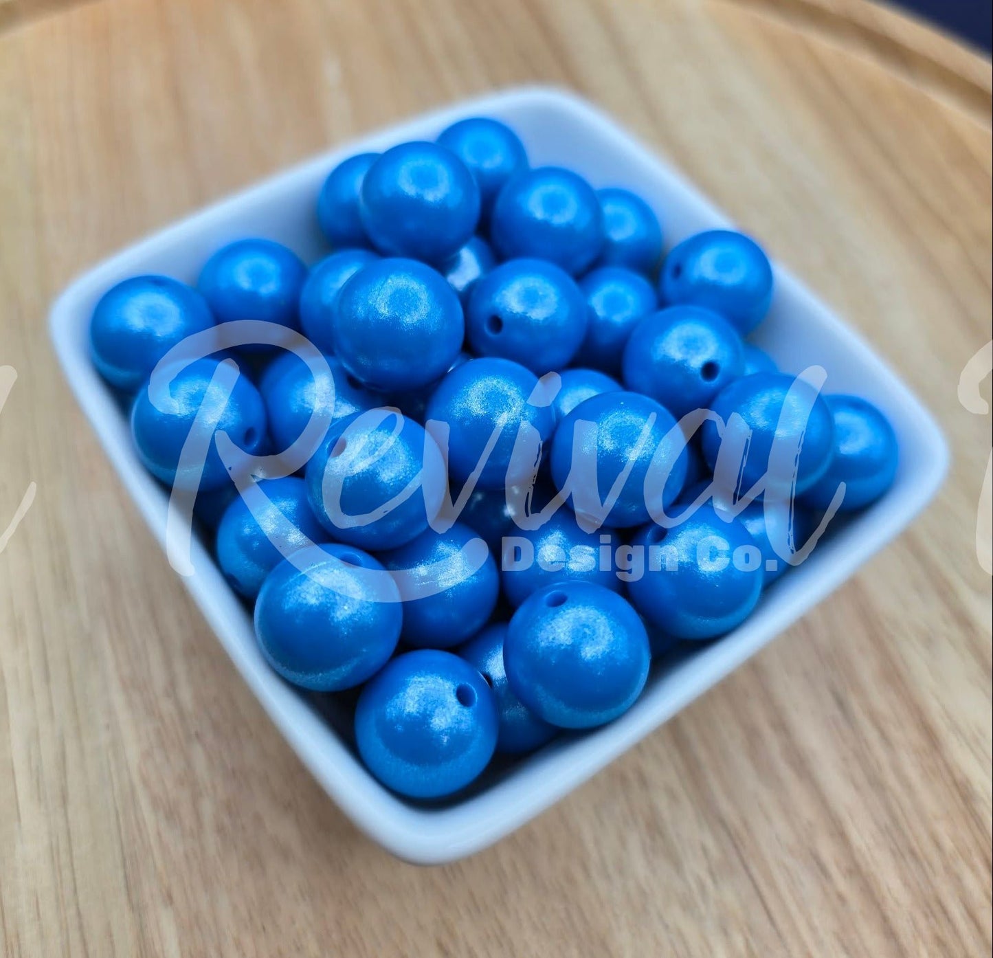 White container filled with blue beads on a wooden surface