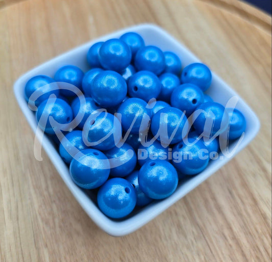 White container filled with blue beads on a wooden surface