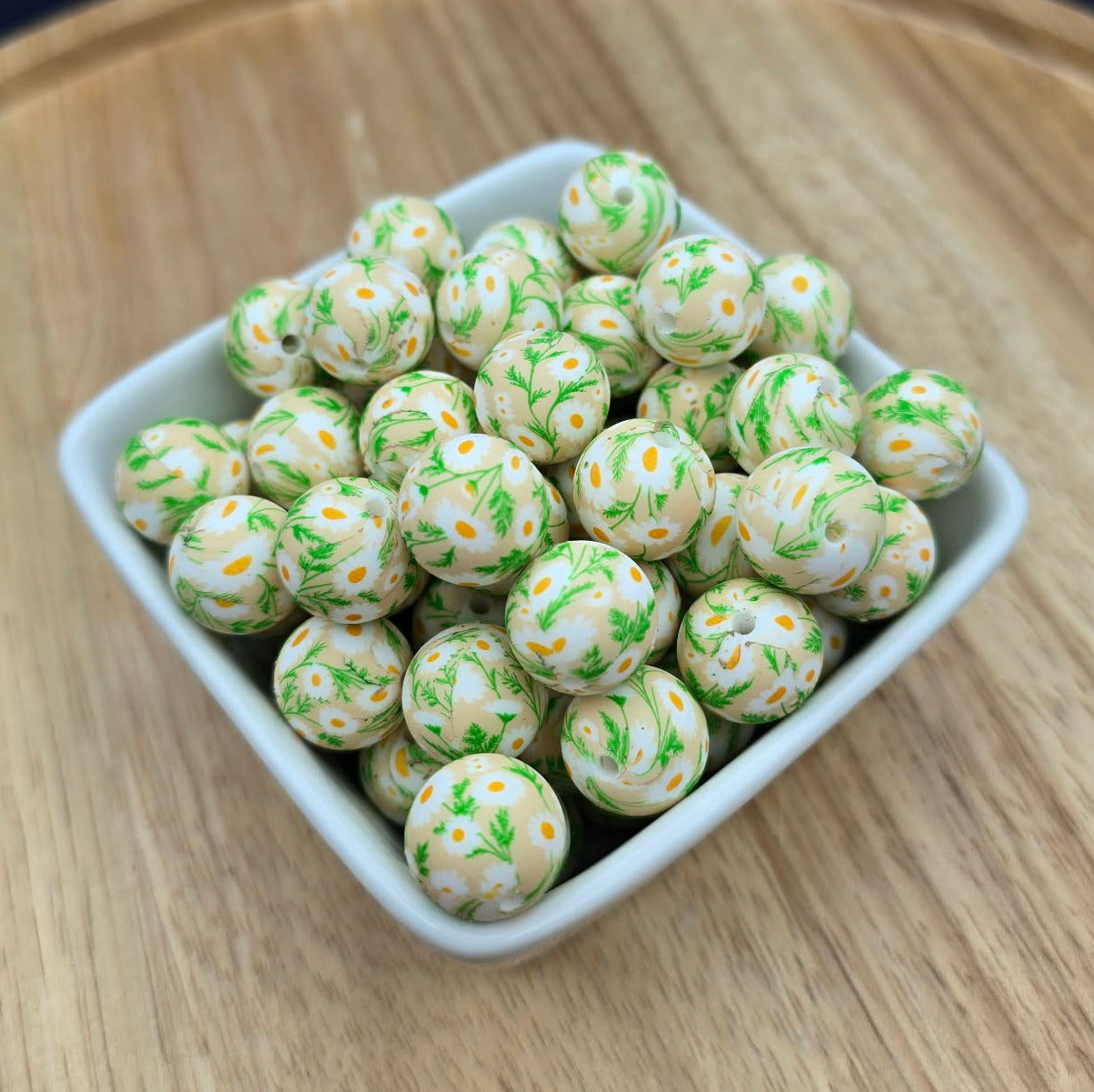 White container filled with green and white floral spherical beads on a wooden surface with a dark background